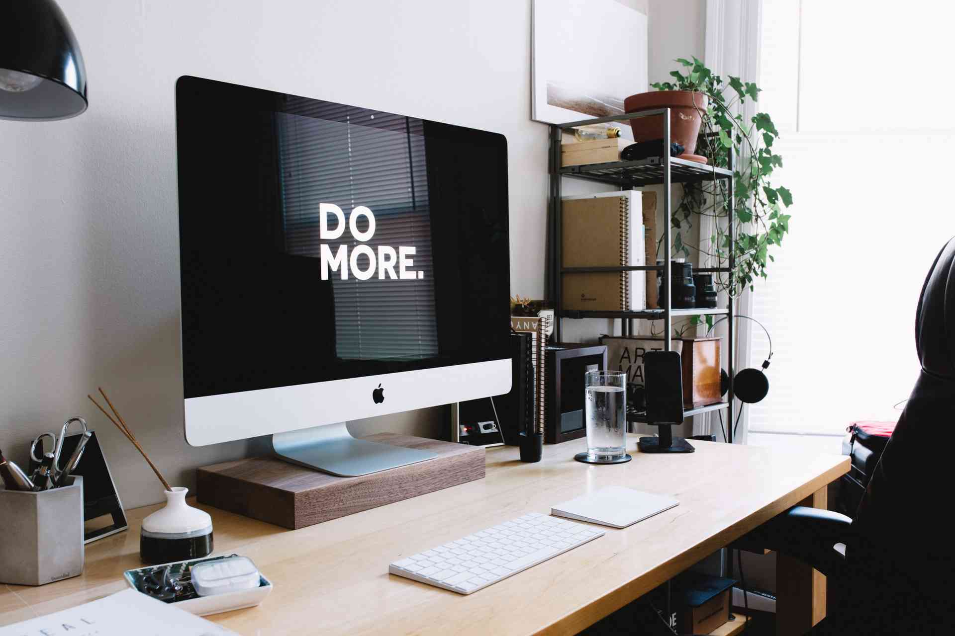 Modern home office desk setup with iMac and do more message on screen at Evermore Co